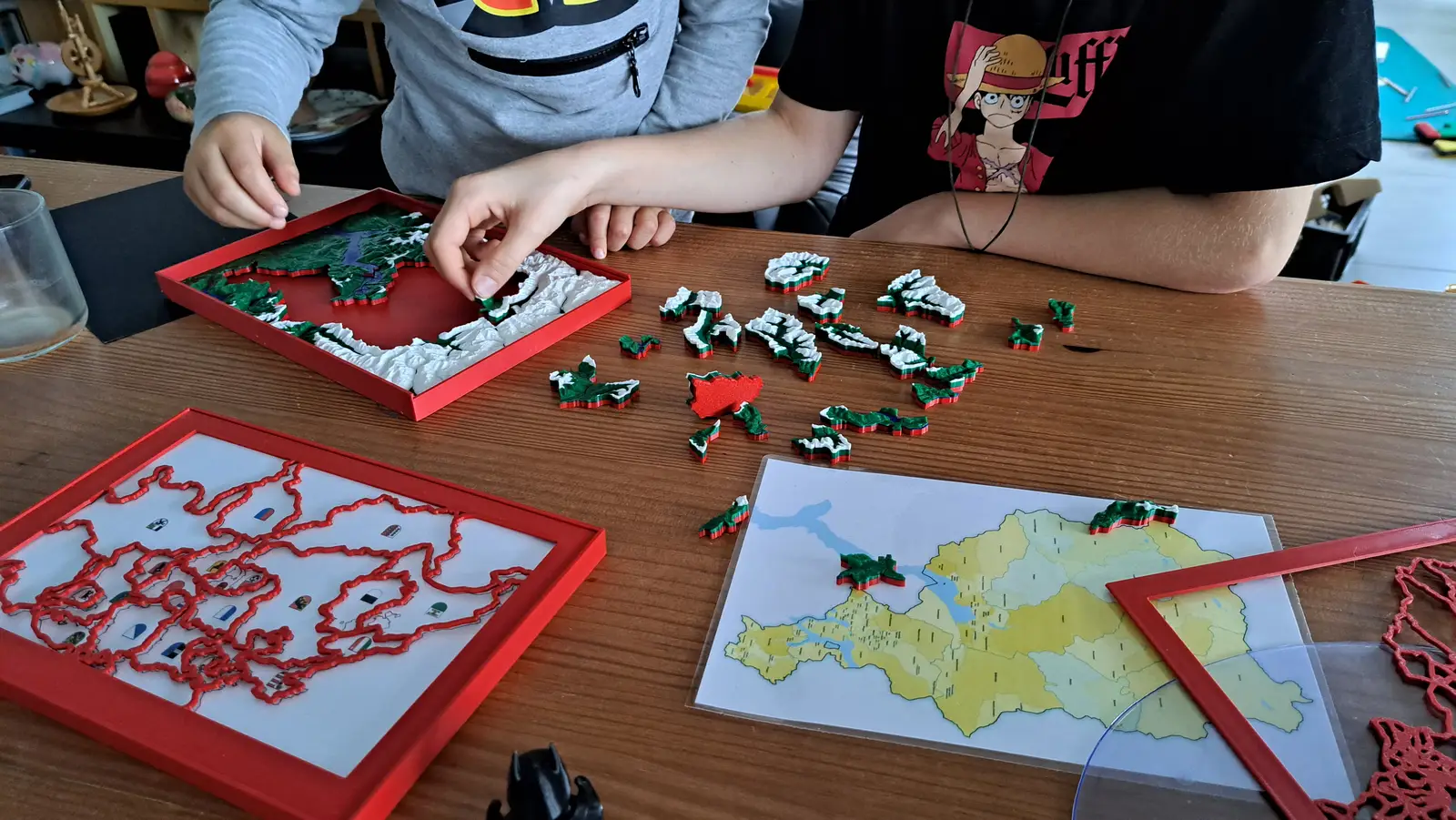 Children at a table assembling Switzerland puzzles next to a cantons worksheet