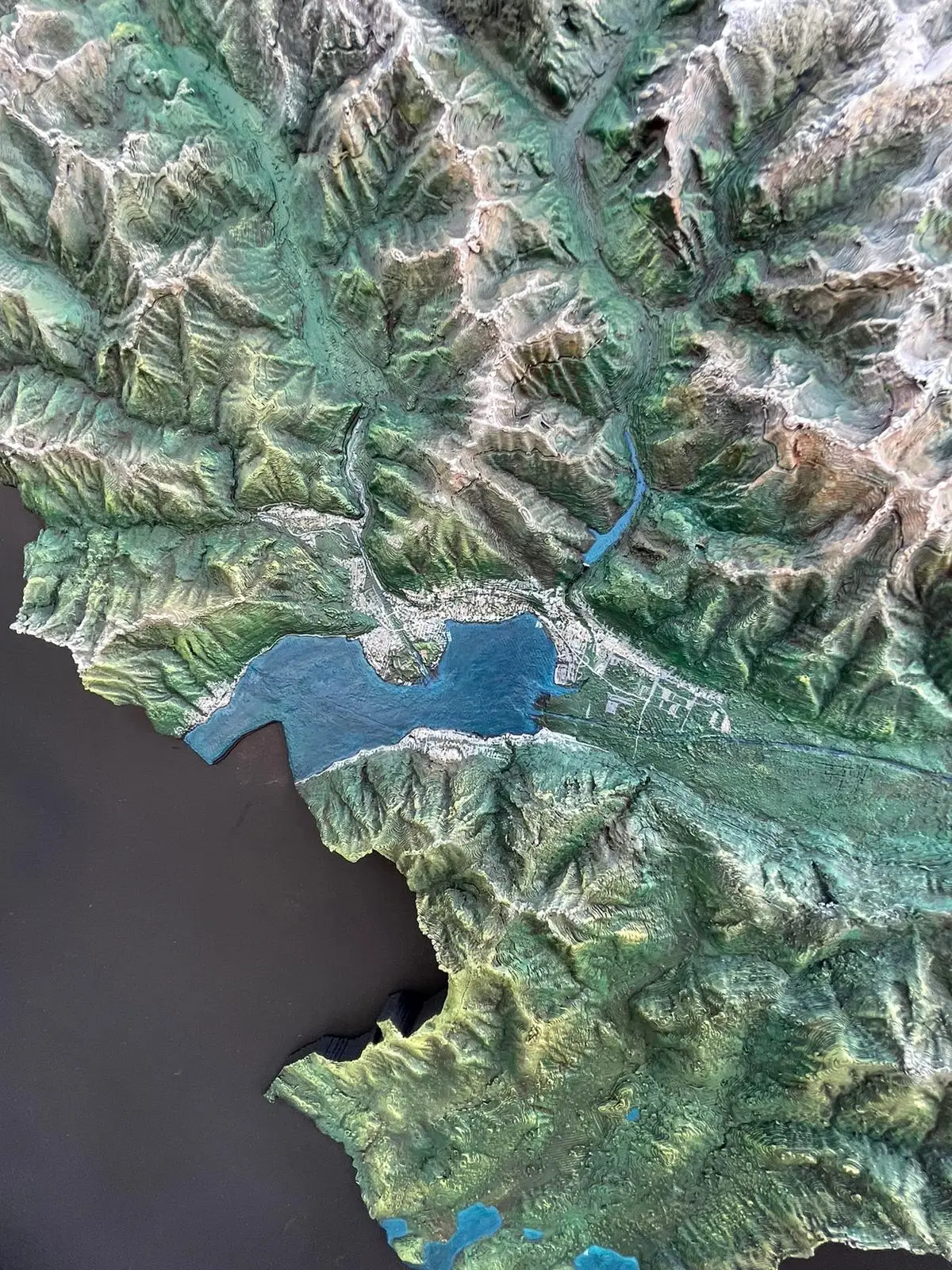 Close-up of the hand-painted Ticino relief with its valleys, snow and Lake Maggiore