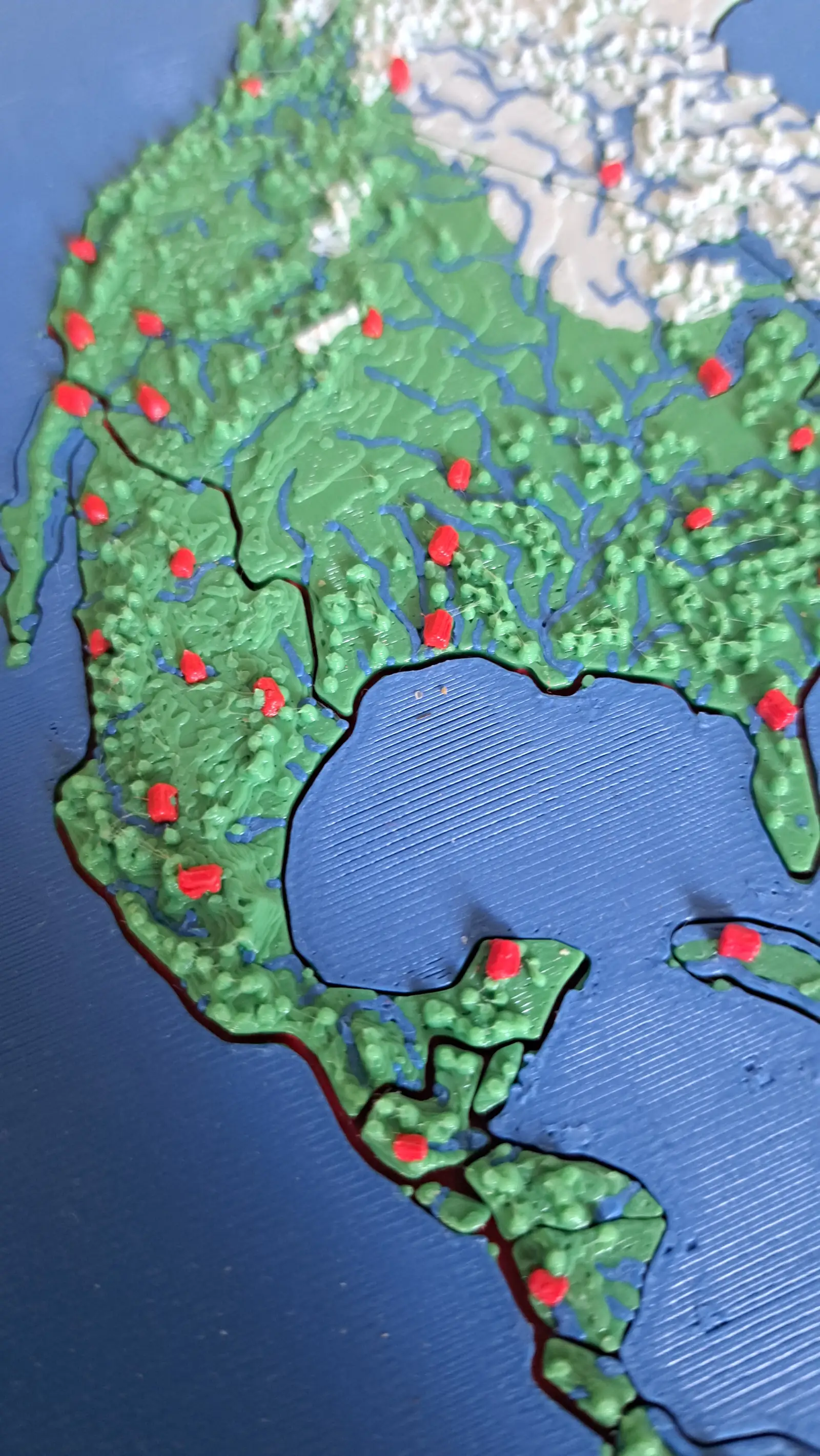Close-up of the North America plate showing printed rivers and the small red house markers that mark cities